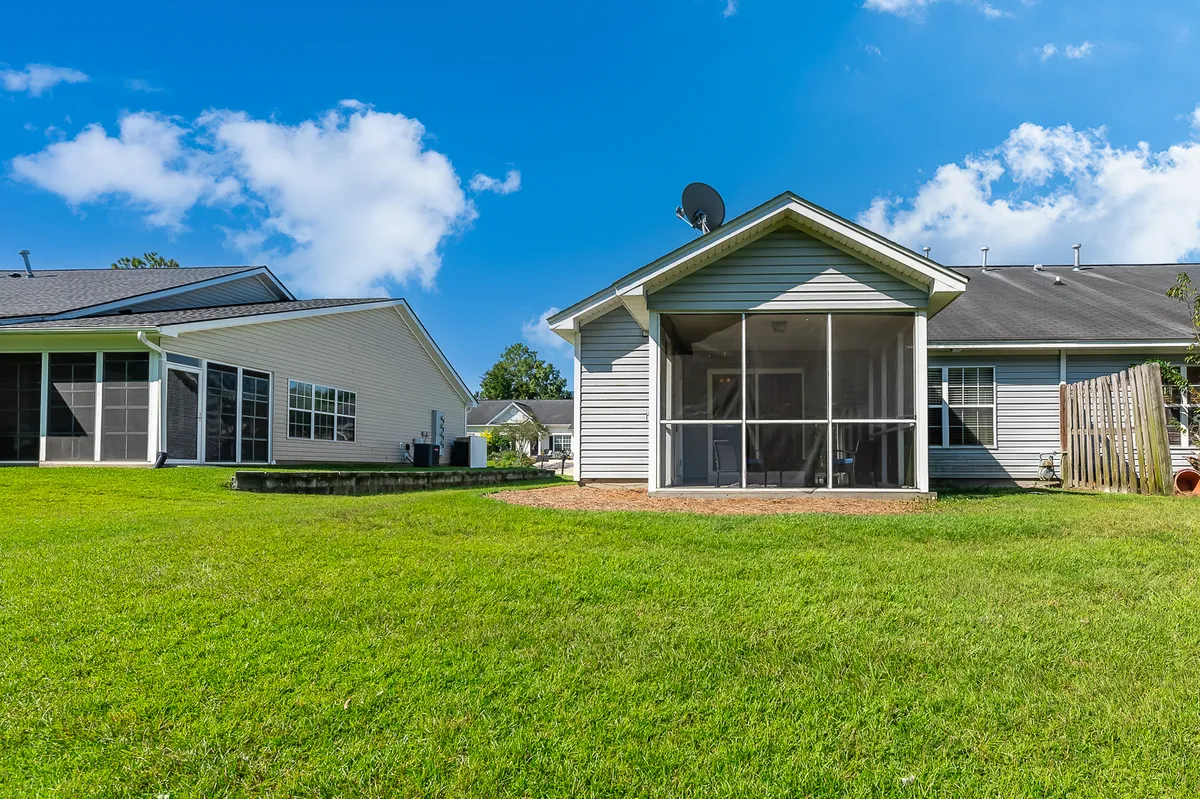 A cheerful screened porch overlooks a well-kept lawn and neighboring houses. The space is perfect for relaxing or gathering after a day of exploring the city, blending indoor comfort with an outdoor feel. The porch hints at family downtime and connecting with the neighborhood.